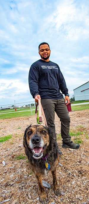 SIU Animal Science Student works with dog on campus