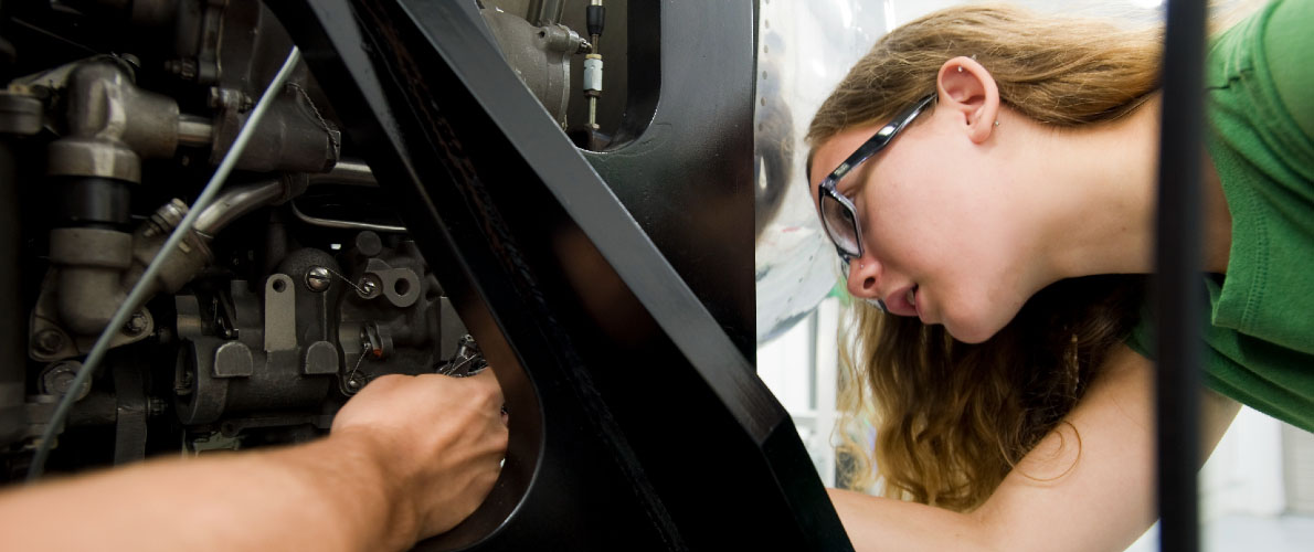 student examining engine