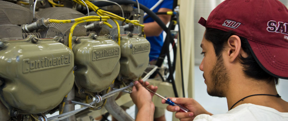 student assembling machinery with screwdriver