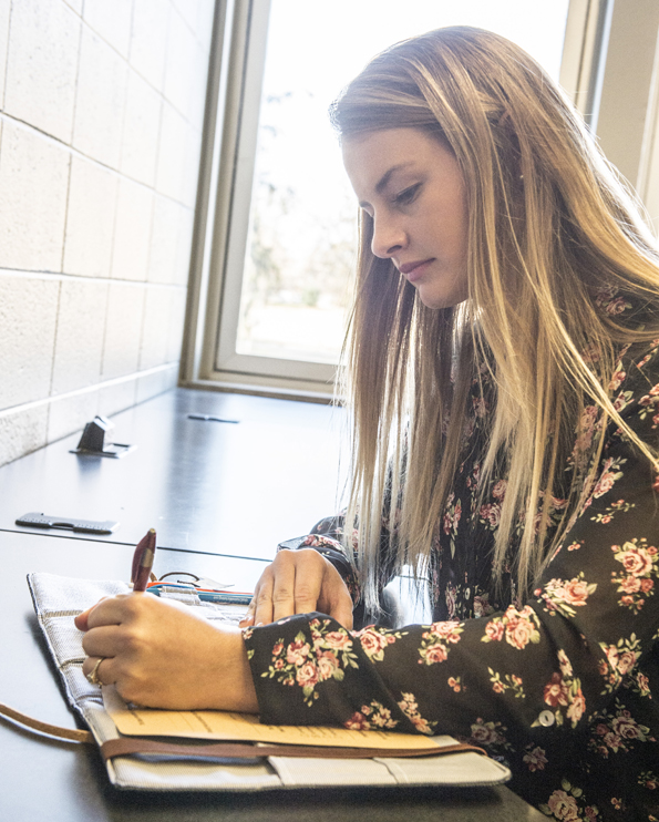 Student writing in notebook