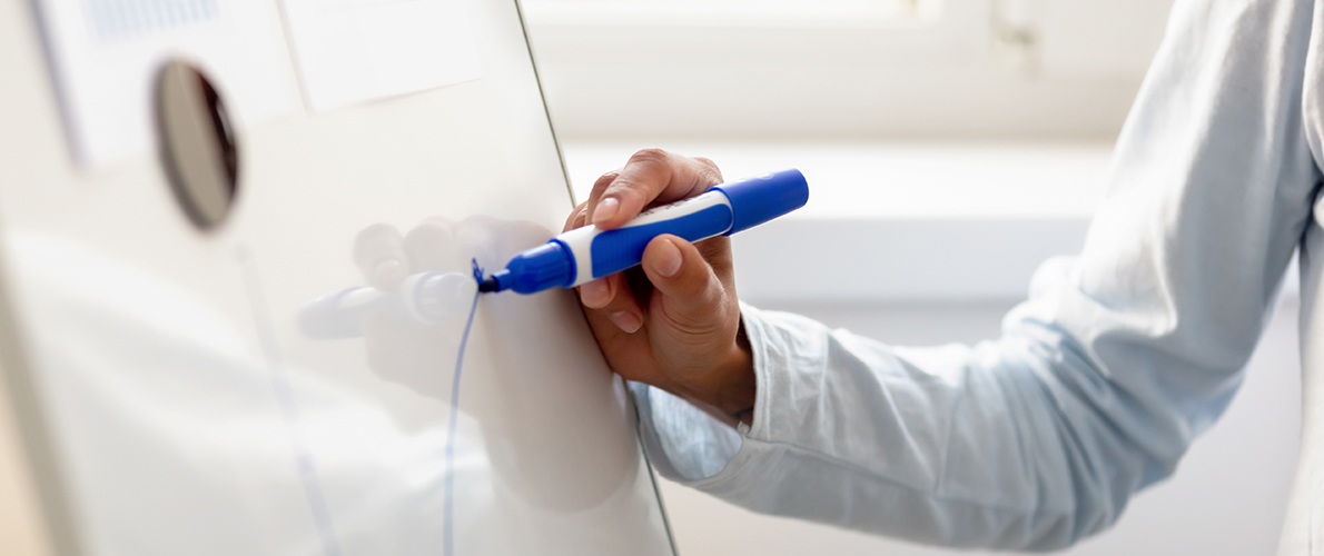 Person writing on white board