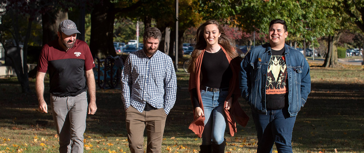 SIU Communication Studies graduate students walking outside during autumn on campus.