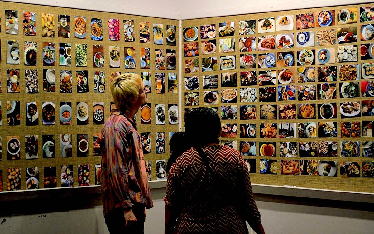 A couple of students view MFA student Shruti Rao's exhibit