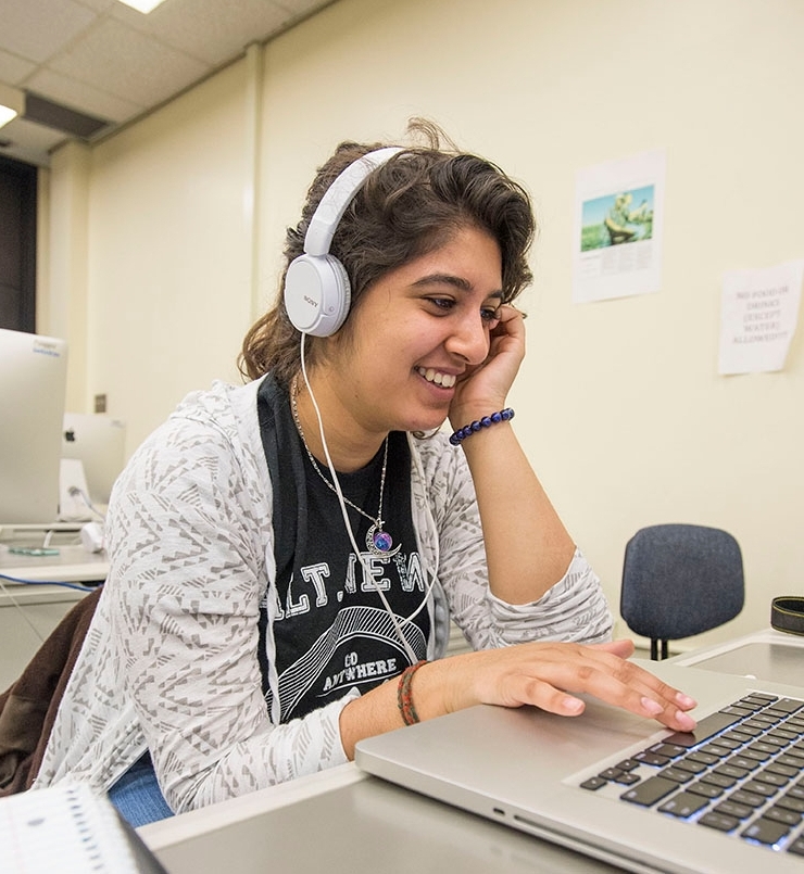 SIU Radio, TV, and Digital media student with headphones and laptop