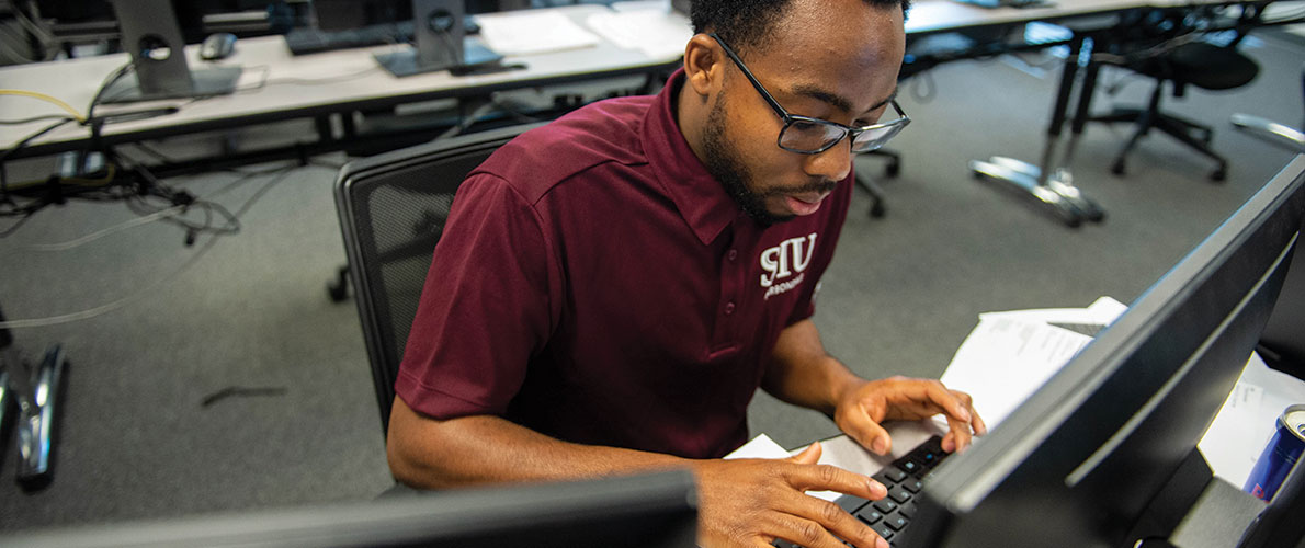 SIU Student member of the Security Dawgs working on computer