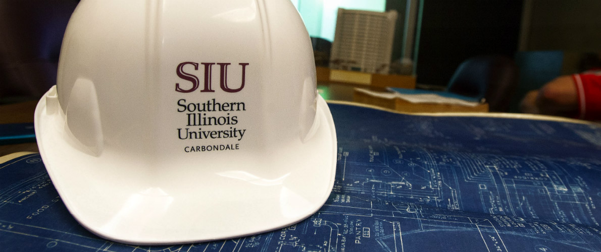 SIU helmet and blueprints for construction management degree