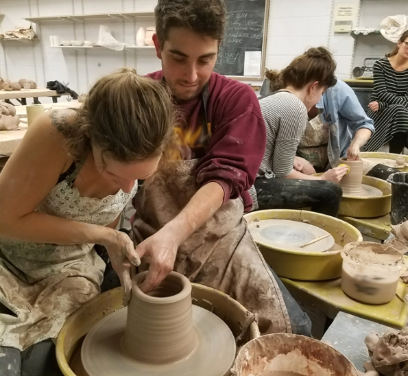 SIU Students working a clay pot