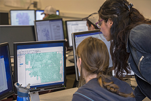 graduate student assisting students in computer lab