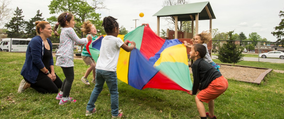 SIU Student Playing with Kids and a parachute