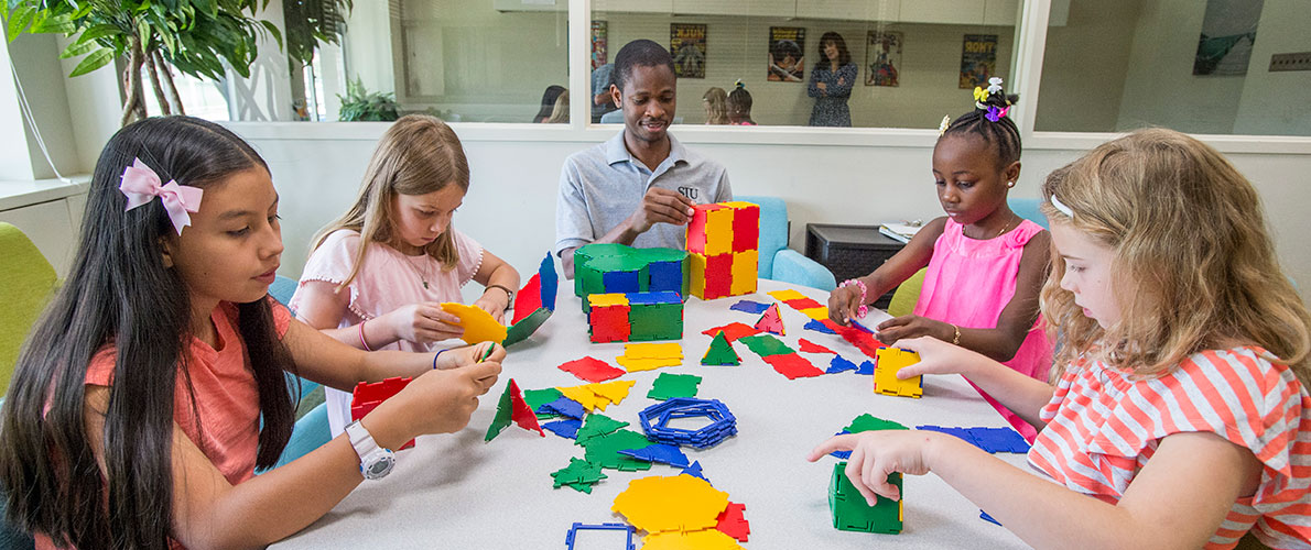 Early Childhood Students work with kids building blocks