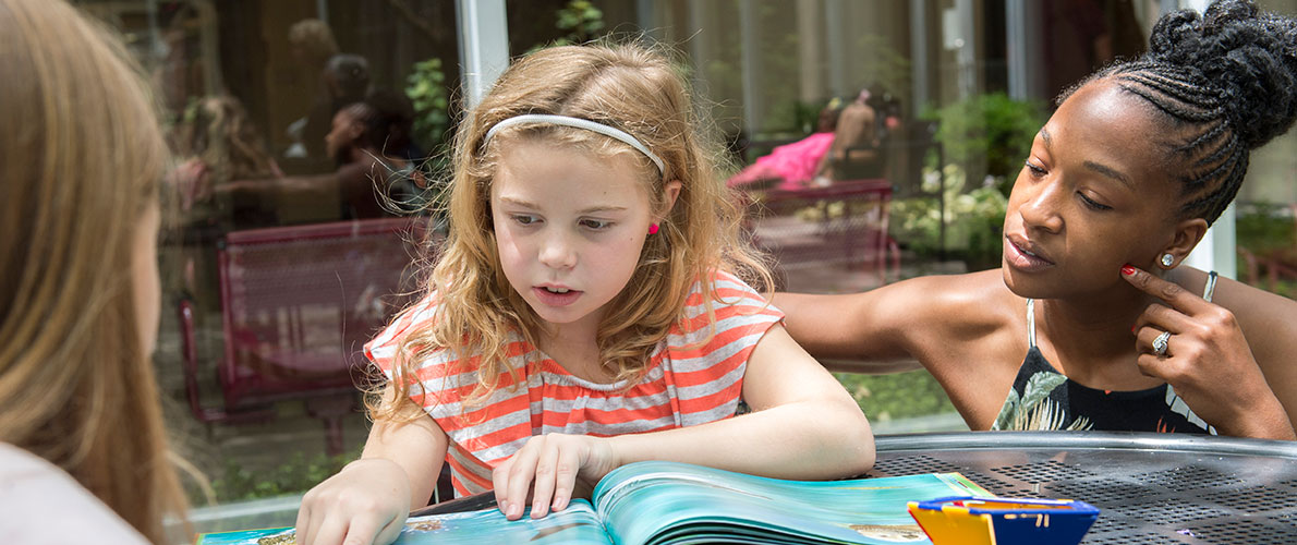 Early Childhood Student works on reading with a childhood