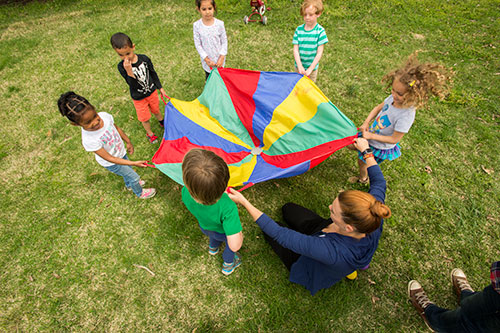 SIU Grow Your Own Teachers Program Kids play with a parachute