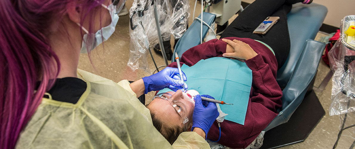 SIU Dental Hygiene Student works on another student 