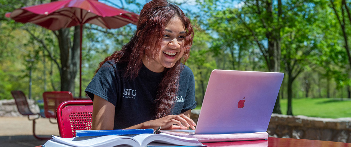 SIU graduate social work student doing homework outside