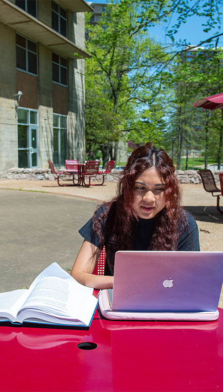 SIU social work student studying outside on campus.