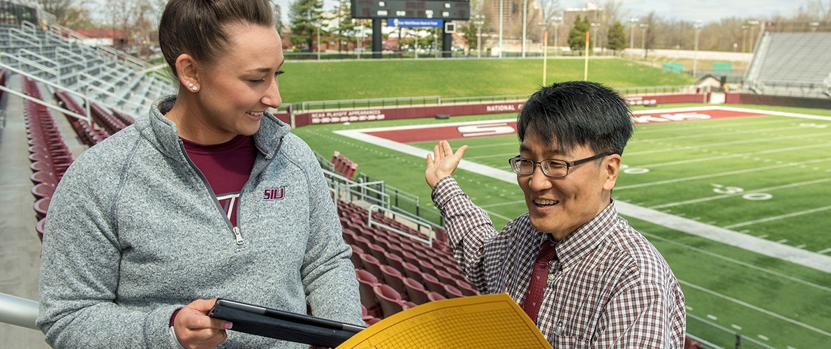 Sports Admin professor with student at stadium