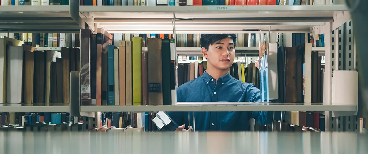 SIU Philosophy Student looks through books