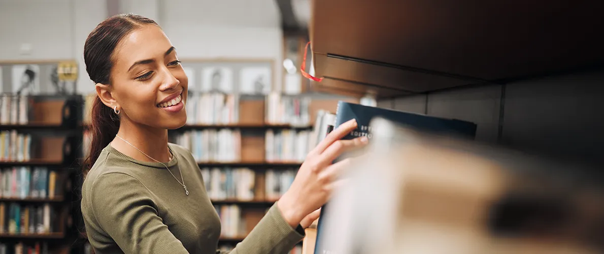 SIU Philosophy Student searches bookshelf at Morris Liberty 