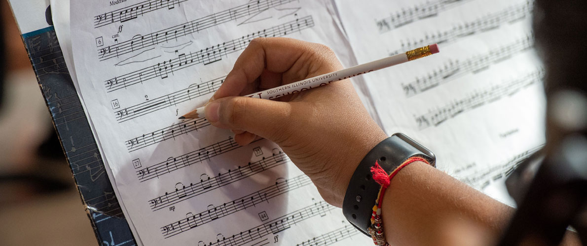 SIU Student making notes on sheet music