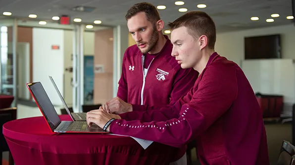 SIU Students work on computer in athletic department